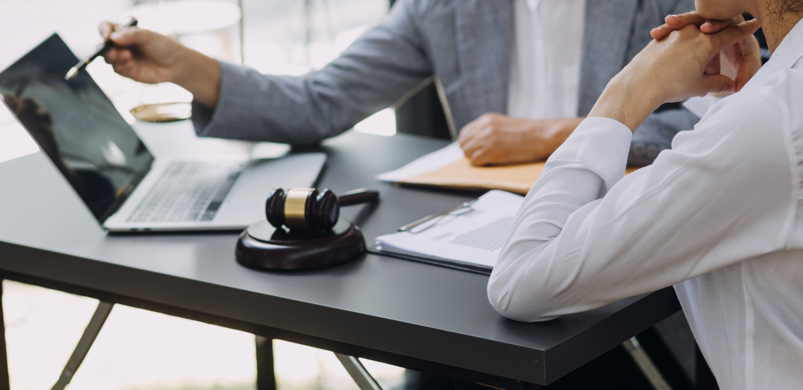 Business and lawyers discussing contract papers with brass scale